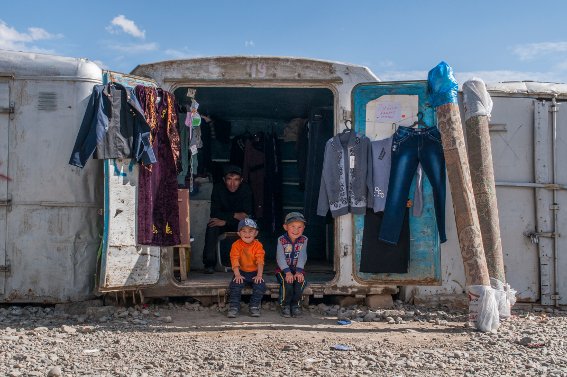 Boys sitting on the edge of bazaar shop in Murghab