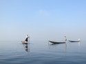 Three inle fishermen rowing with their legs