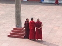 Three monks standing by obelisk