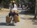 Woman biking through village outside of mandalay