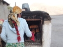 Woman taking bread out of the oven